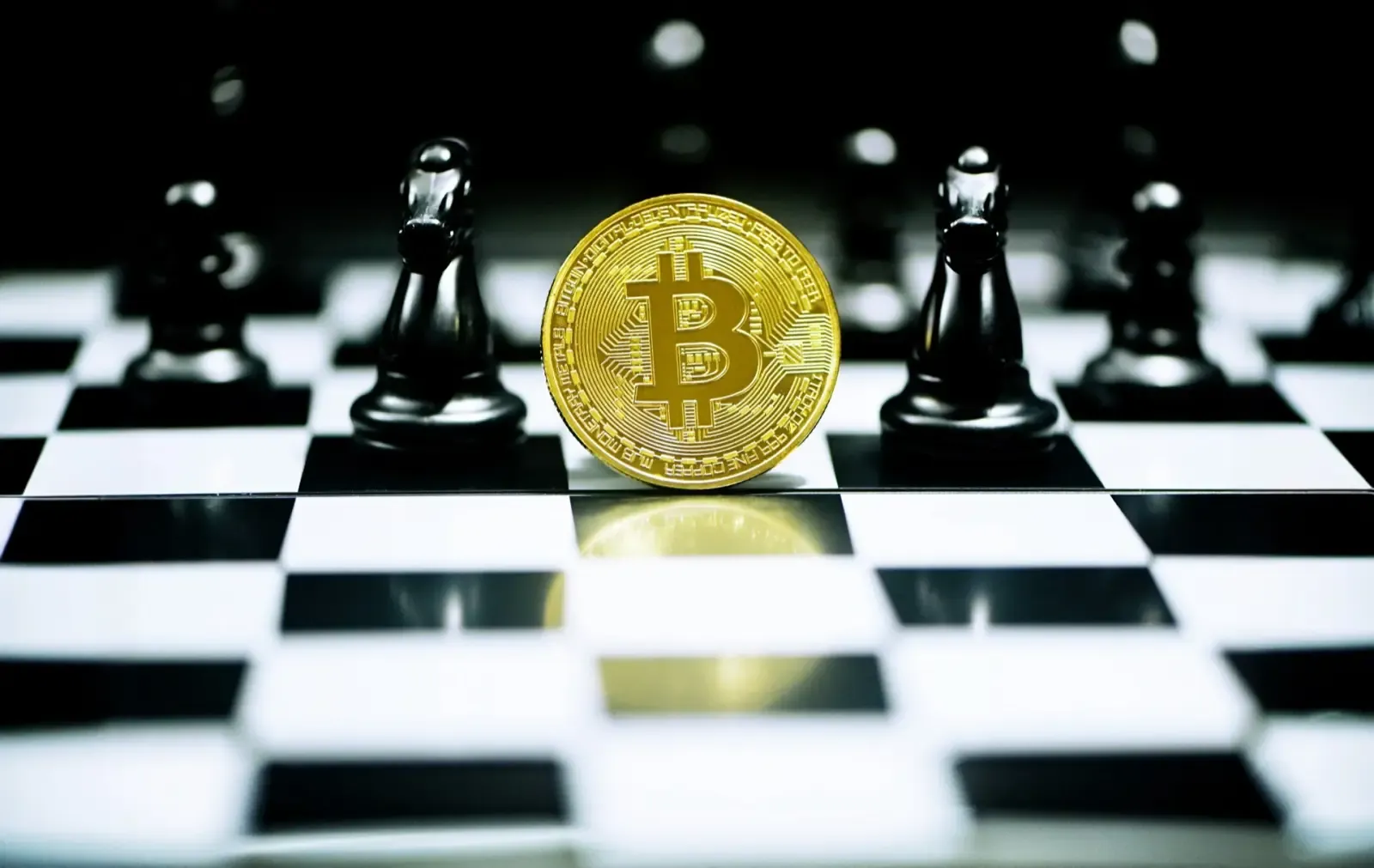 A gold Bitcoin coin standing upright on a chessboard
